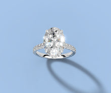 Load image into Gallery viewer, Overhead angled view of oval lab diamond hidden halo engagement ring in 14k white gold