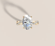 Load image into Gallery viewer, Top view of oval lab diamond engagement ring with four-prong setting and twisted pave shank in 14k yellow gold