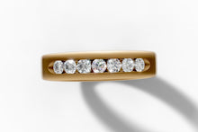 Load image into Gallery viewer, Top-down close-up of the recessed channel with seven round brilliant diamonds in 14k yellow gold