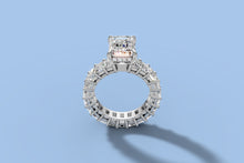 Load image into Gallery viewer, Front view of emerald-cut lab diamond ring with hidden halo above a full eternity band of emerald-cut diamonds in 14k white gold