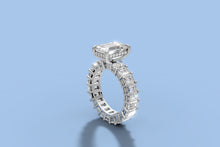 Load image into Gallery viewer, Three-quarter view from the opposite side of the emerald-cut diamond ring showing the hidden halo and the shared-prong eternity shank of emerald-cut diamonds in 14k white gold