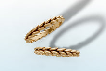 Load image into Gallery viewer, The two wheat braid bands from the set laid apart, one seen edge-on in 14k yellow gold