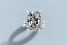 Load image into Gallery viewer, Top view of radiant-cut lab diamond ring set showing four claw prongs and the double row of round brilliants on the band in 14k white gold
