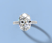 Load image into Gallery viewer, Top view of oval lab diamond ring with four-prong setting and single-row pave band in 14k white gold
