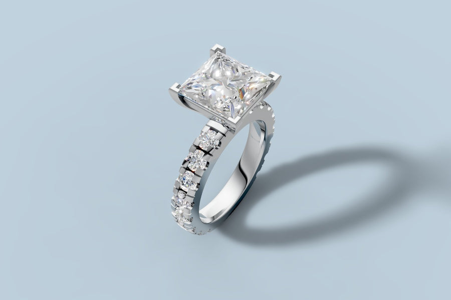 Princess-cut lab diamond engagement ring with four-prong V setting and shared-prong round brilliant band in 14k white gold, three-quarter view