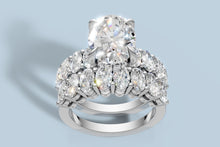 Load image into Gallery viewer, Front three-quarter view of the oval diamond engagement ring set showing the four-prong center, hidden halo and two rows of oval accents in 14k white gold
