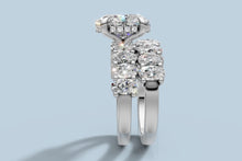 Load image into Gallery viewer, Side profile of the stacked oval diamond set revealing the hidden halo of round brilliants beneath the center basket
