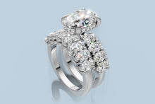 Load image into Gallery viewer, Angled view from the opposite side of the oval diamond ring set showing the hidden halo and oval accents on both rings in 14k white gold
