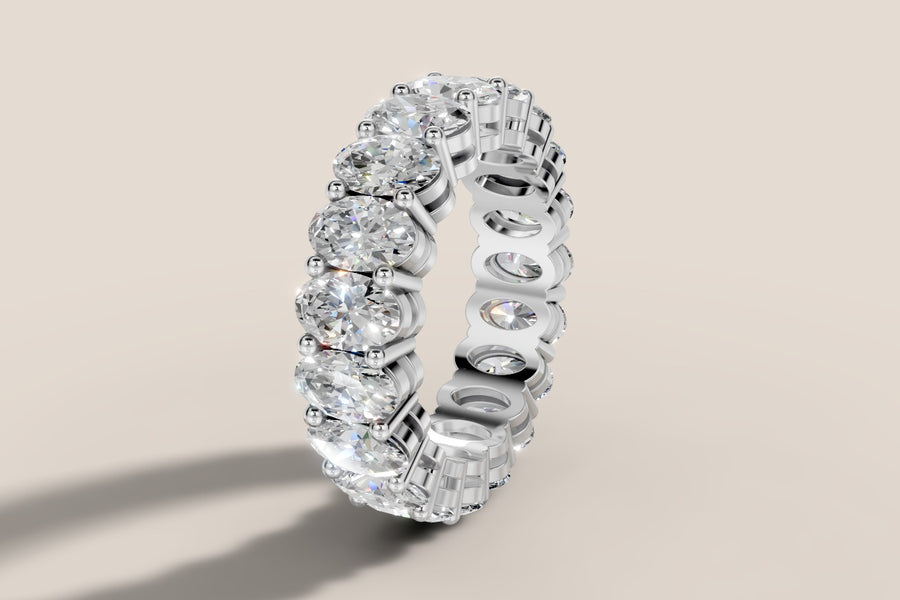 Oval lab diamond eternity band in 14k white gold standing upright, three-quarter view showing shared beaded prongs and open U-shaped gallery
