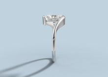 Load image into Gallery viewer, Side profile of radiant diamond bypass ring showing the half-bezel bars gripping the ends of the stone in 14k white gold
