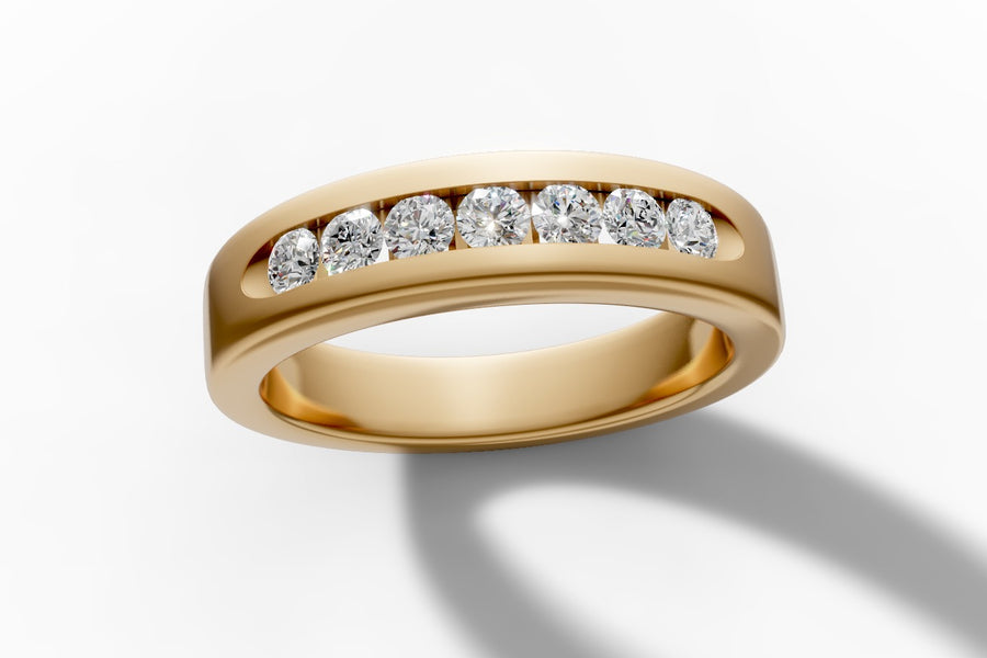Channel-set diamond band in 14k yellow gold, angled view showing seven round brilliant lab diamonds set flush in the channel
