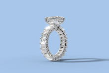 Load image into Gallery viewer, Side profile of emerald-cut diamond eternity ring revealing the hidden halo of round brilliants beneath the basket
