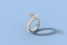 Load image into Gallery viewer, Elevated three-quarter view of emerald-cut diamond eternity engagement ring with hidden halo in 14k white gold
