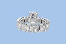 Load image into Gallery viewer, Underside view of emerald-cut diamond eternity ring showing the open gallery, hidden halo and pave prong bridges in 14k white gold
