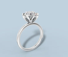 Load image into Gallery viewer, Low three-quarter view of round diamond tulip solitaire ring showing the curved prongs beneath the stone in 14k white gold
