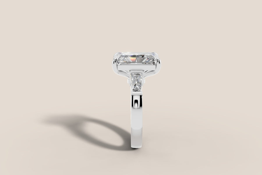 Radiant-cut diamond ring with tapered baguette side stones in 14k white gold, profile view