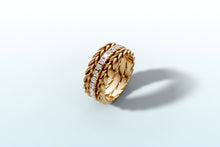 Load image into Gallery viewer, Angled view of the three stacked bands in 14k yellow gold with the diamond band catching the light
