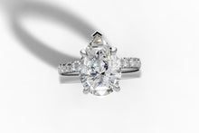 Load image into Gallery viewer, Top-down view of pear diamond ring showing polished band and french-pave band in 14k white gold

