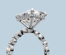 Load image into Gallery viewer, Close-up of the hidden halo of round brilliants beneath the radiant center and the marquise and round bezels on the band
